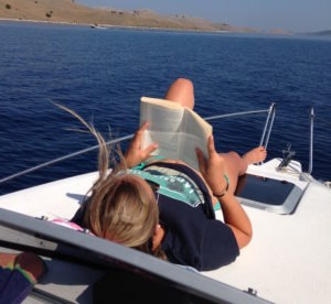 Frau B. liegt auf dem Bug Ihrer 20 -Yachtline- und liest ein Buch