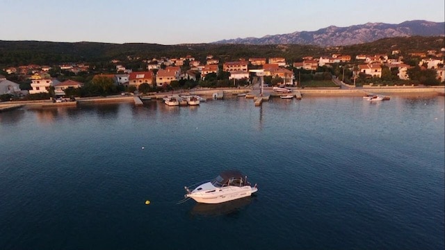 Das Foto einer Drohne zeit die 23 -Yachtline- wie sie an einer Boje vor dem Ufer festgemacht wurde.