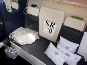 Das Foto zeigt den Lounge Bereich der SR30 -Yachtline-. Hier liegen Decken und Kissen, vor der Sitzgruppe steht Mineralwasser.