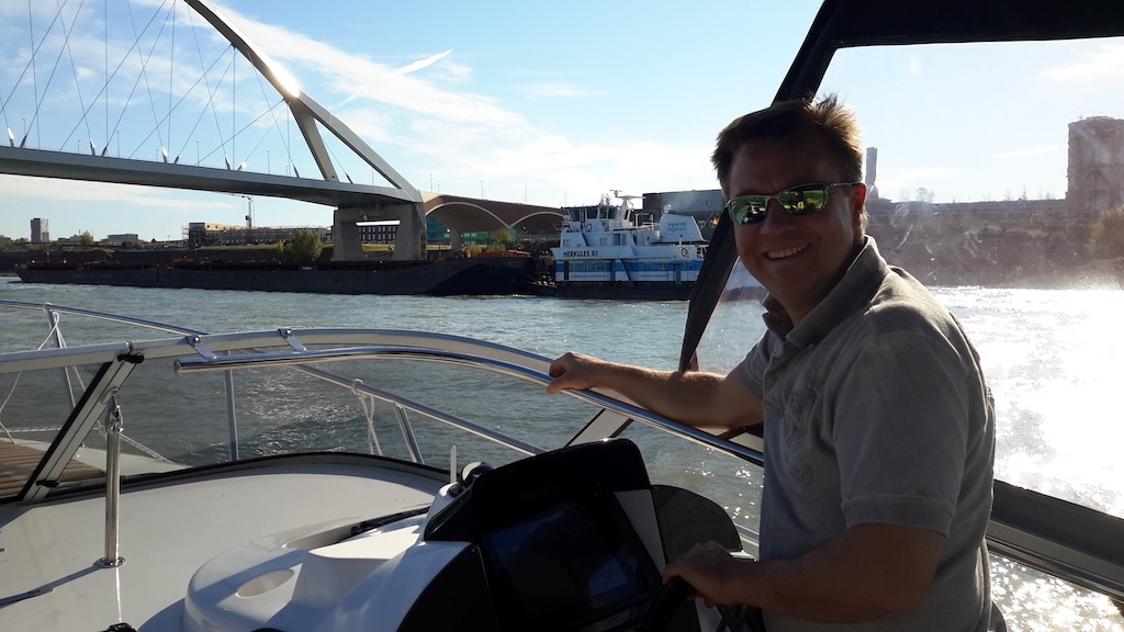 Das Foto zeigt Herrn T. beim steuern der SR30 -Yachtline-, er trägt ein ein verspiegelte Sonnenbrille und lächelt in die Kamera.